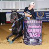youth barrel racer turning around a barrel on her horse